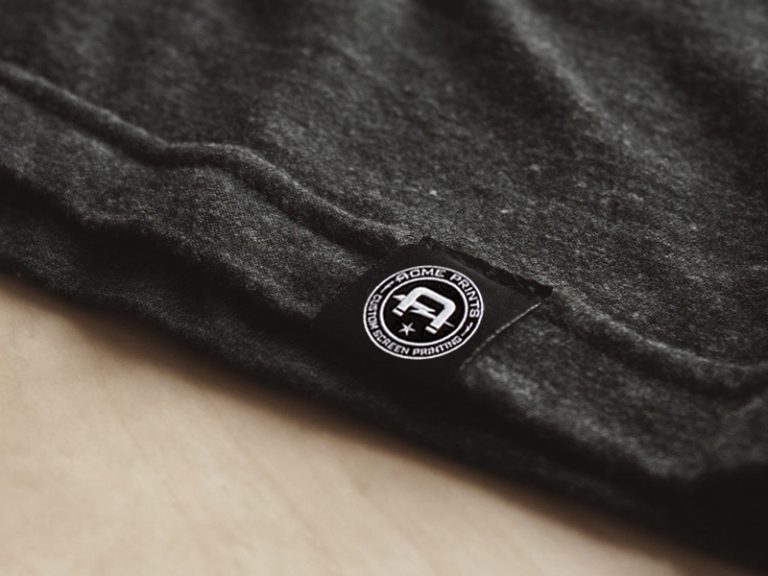Acme Prints branded hem label sewn onto a tri-blend shirt.