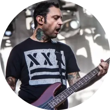 Joe Principe from the band Rise Against wearing an Underground Faction t-shirt with the design Out of Step on the front while playing bass and singing on stage.