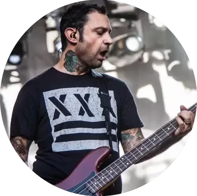 Joe Principe from the band Rise Against wearing an Underground Faction t-shirt with the design Out of Step on the front while playing bass and singing on stage.